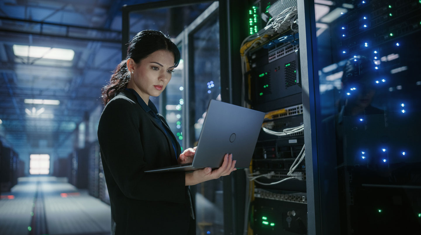 Salle serveur avec technicien configurant l'infrastructure d'intégration entre systèmes d'information